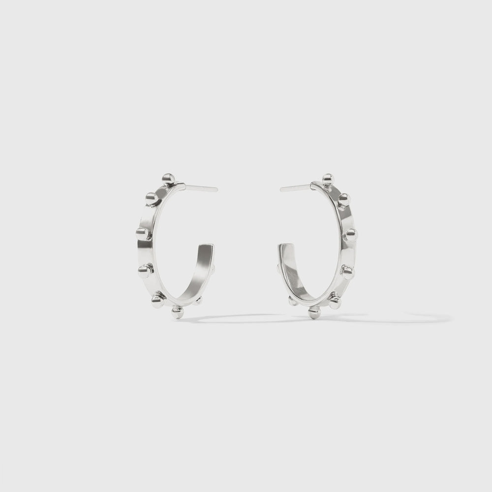 Silver earrings by Celine featuring a pair of open-hoop studs adorned with raised spherical accents and a high-shine polished finish against a neutral studio background