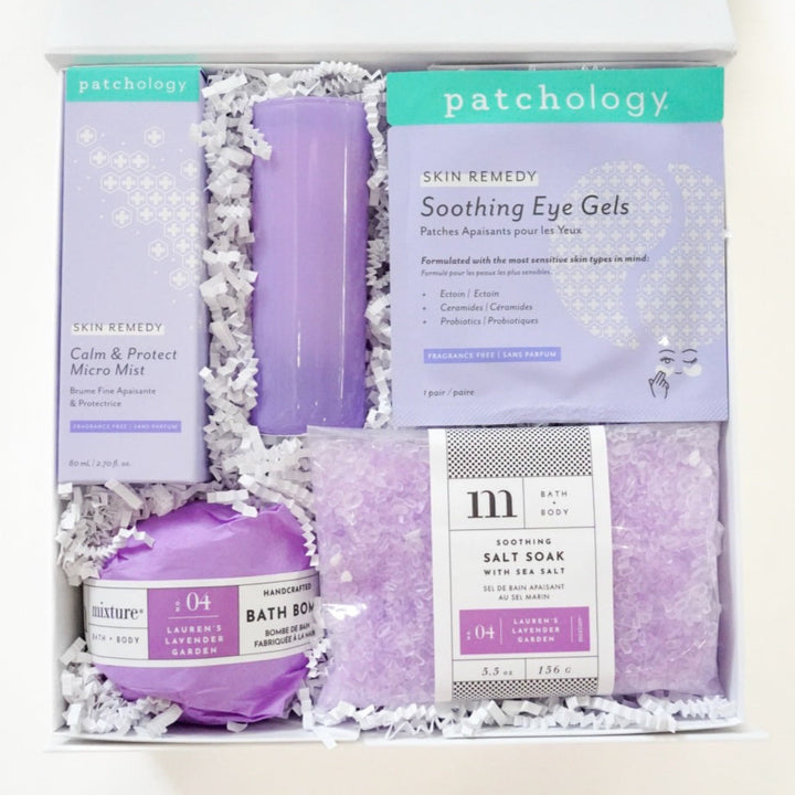 Photograph of a Patchology and Mixture curated spa gift box containing lavender-themed skincare including a purple candle, soothing eye gels, and Lauren&