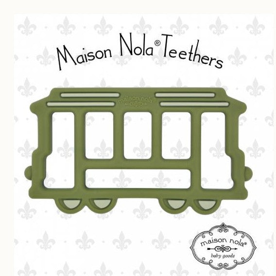 Silicone baby teether by Maison Nola featuring an olive green St. Charles Avenue streetcar from New Orleans with rectangular window cut-outs and a grey fleur-de-lis patterned background