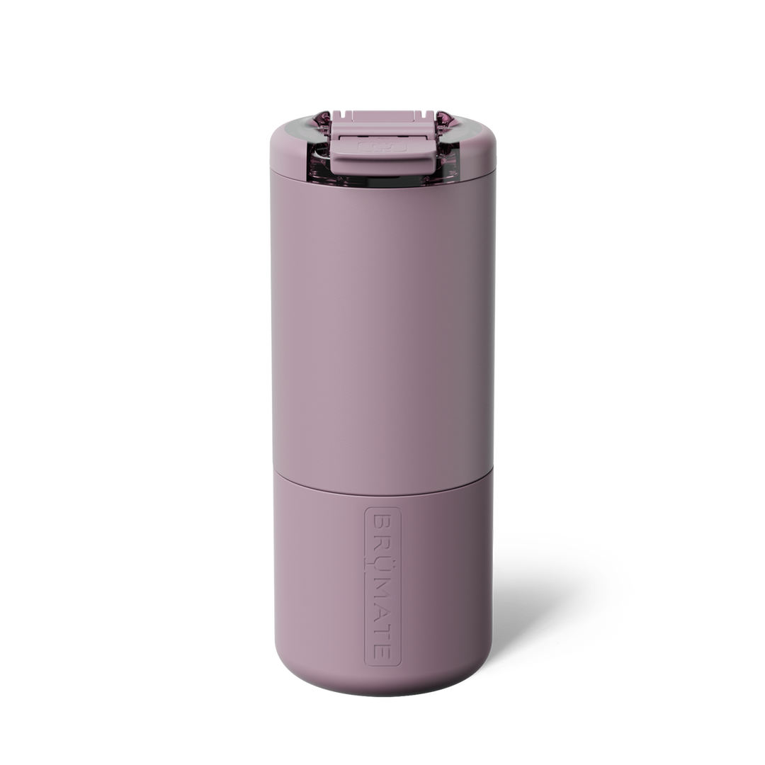 Product photograph of a BrüMate insulated tumbler in a mauve color centered on a plain white background featuring a matte finish, a transparent flip-top lid, and an embossed vertical logo
