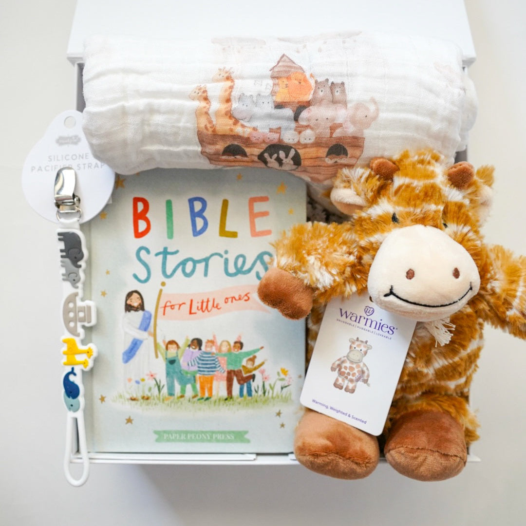 Children's book titled 'Bible Stories for Littles' with a plush toy and a white lamp on a light gray background