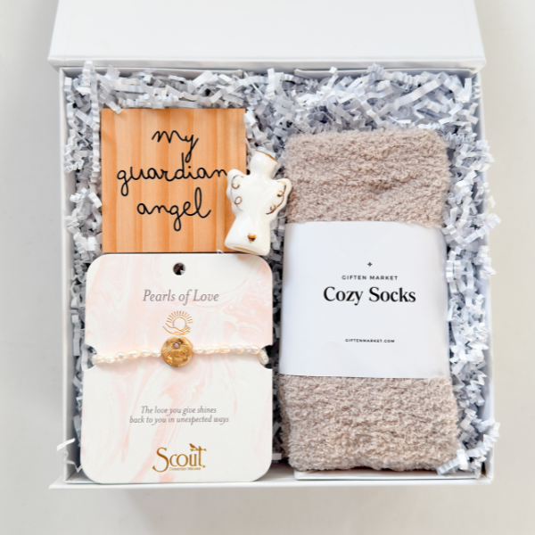 Gift set with 'my guardian angel' card, bracelet, soap, and socks in a box.