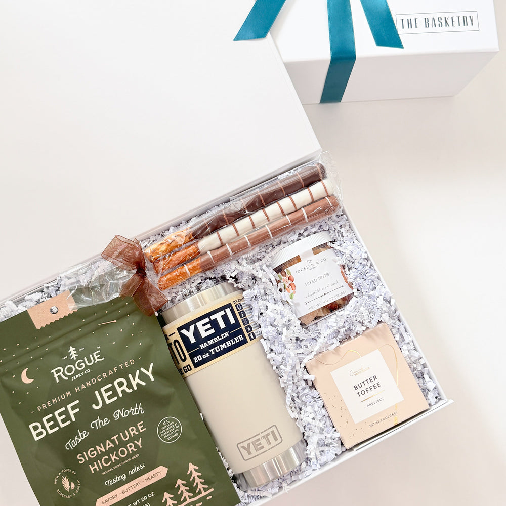 Gift set with beef jerky, Yeti mug, and other items on a white background