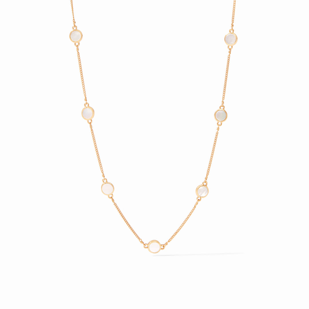 Yellow gold necklace featuring iridescent circular white mother-of-pearl stations in smooth bezel settings along a delicate link chain centered against a minimalist white background