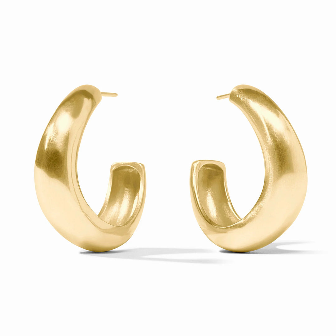 Gold jewelry photography of chunky yellow gold hoop earrings on a white background featuring a soft brushed finish and a tapered crescent-shaped silhouette with visible metal posts