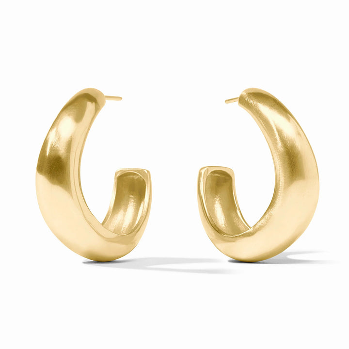 Gold jewelry photography of chunky yellow gold hoop earrings on a white background featuring a soft brushed finish and a tapered crescent-shaped silhouette with visible metal posts