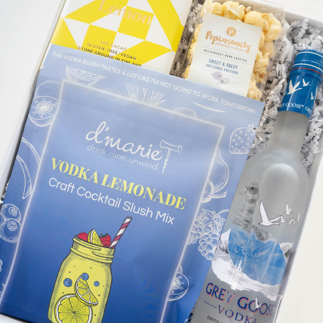 Photograph of a luxury cocktail gift box containing a frosted bottle of Grey Goose Vodka, a d&