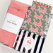 Set of pink cozy socks, black and white striped candy, and a notebook with tiger pattern on a light gray background