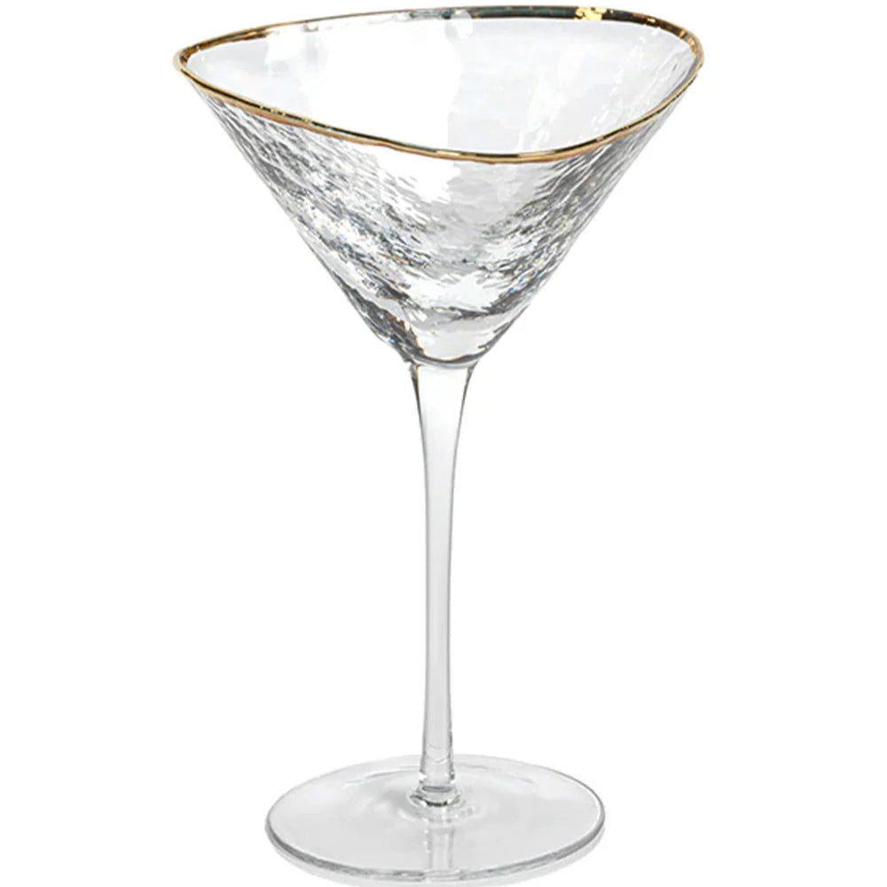 Hand-blown glass martini glass positioned in a studio setting featuring a shimmering gold-trimmed rim and a textured hammered finish on the clear triangular bowl