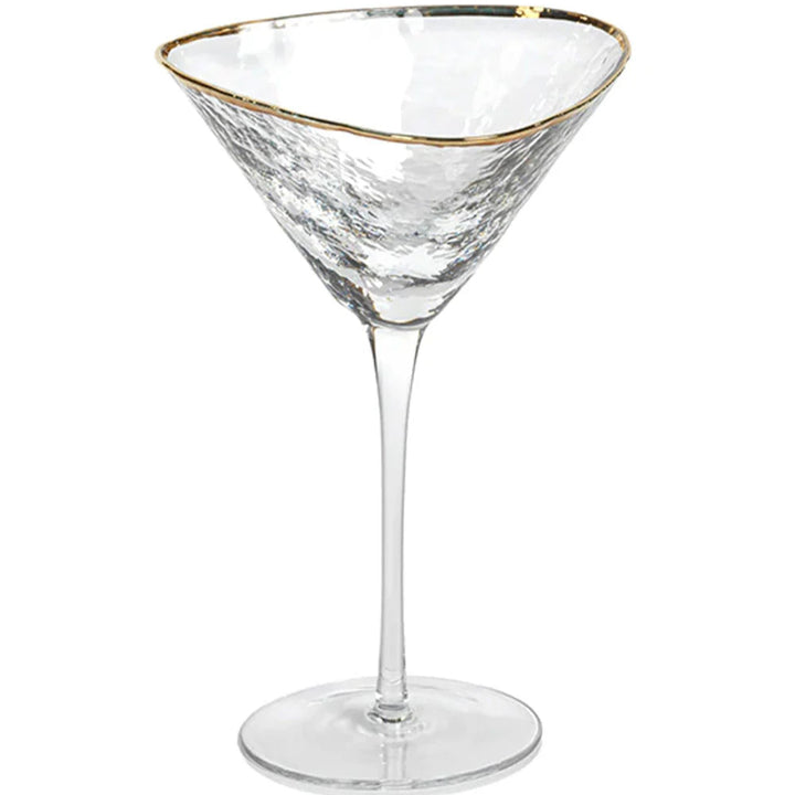 Hand-blown glass martini glass positioned in a studio setting featuring a shimmering gold-trimmed rim and a textured hammered finish on the clear triangular bowl