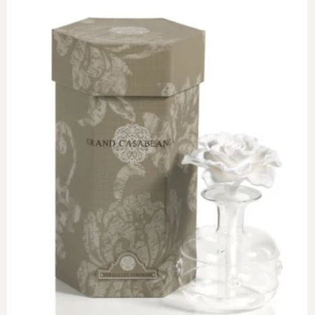 Product photography of an Aromatique Grand Casablanca fragrance diffuser set featuring a hexagonal taupe damask-patterned gift box and a clear glass bottle topped with a delicate white ceramic rose flower