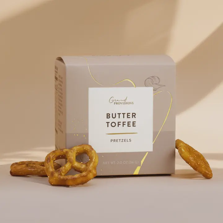 Gray Grand Provisions Butter Toffee Pretzels box with toffee-coated pretzels beside it