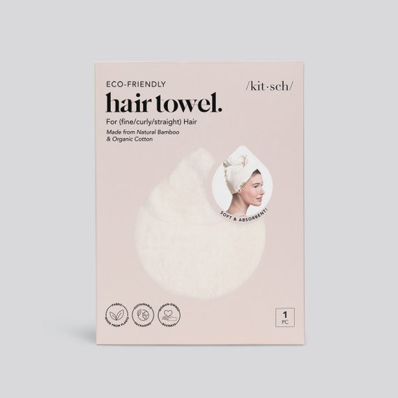 Product photography for Kitsch featuring eco-friendly hair towel packaging on a neutral background with the Kitsch logo, a textured white fabric cutout, and a circular inset of a woman wearing a white towel wrap on a blush pink box
