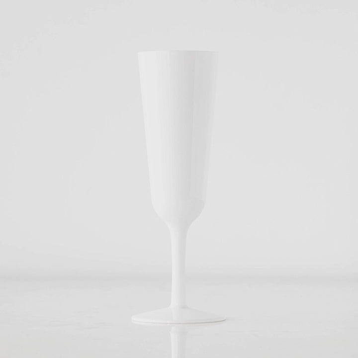 A photograph of an opaque white champagne flute in a minimalist studio setting featuring a long slender stem and a seamless high-gloss finish