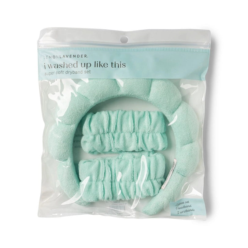 Product photography by Lemon Lavender of a mint green super soft dryband set in clear plastic packaging featuring a puffy quilted headband and two matching wristbands with the printed text i washed up like this