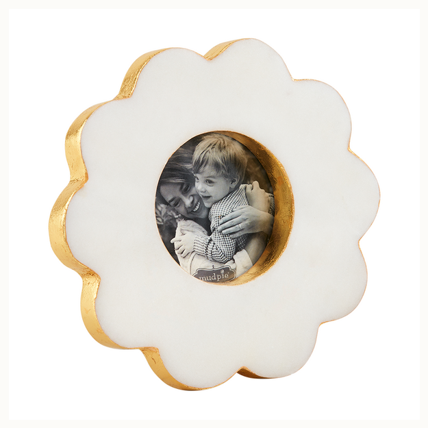 White marble flower-shaped frame with gold edges holding a round black and white photo