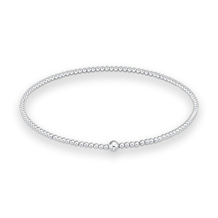 Sterling silver beaded bracelet featuring a large polished central focal bead and a continuous strand of uniform high-shine spherical beads on a white studio background