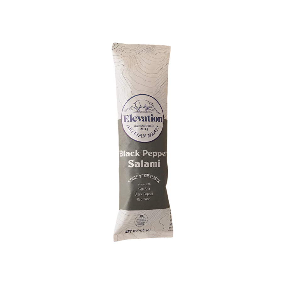 Commercial product photography of Elevation Artisan Meats Black Pepper Salami stick on a white background featuring a blue pig and mountain logo, topographical line patterns, and an olive-colored label listing sea salt and red wine