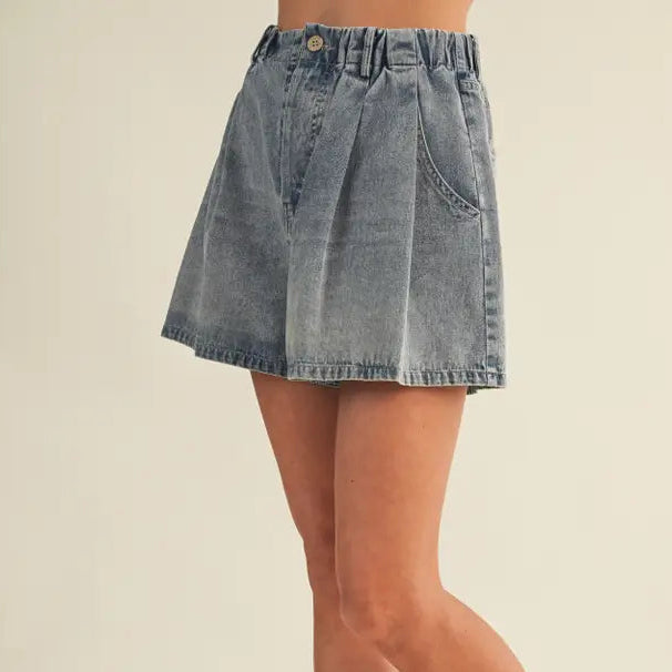 Angled view of vintage wash pleated wide leg denim shorts