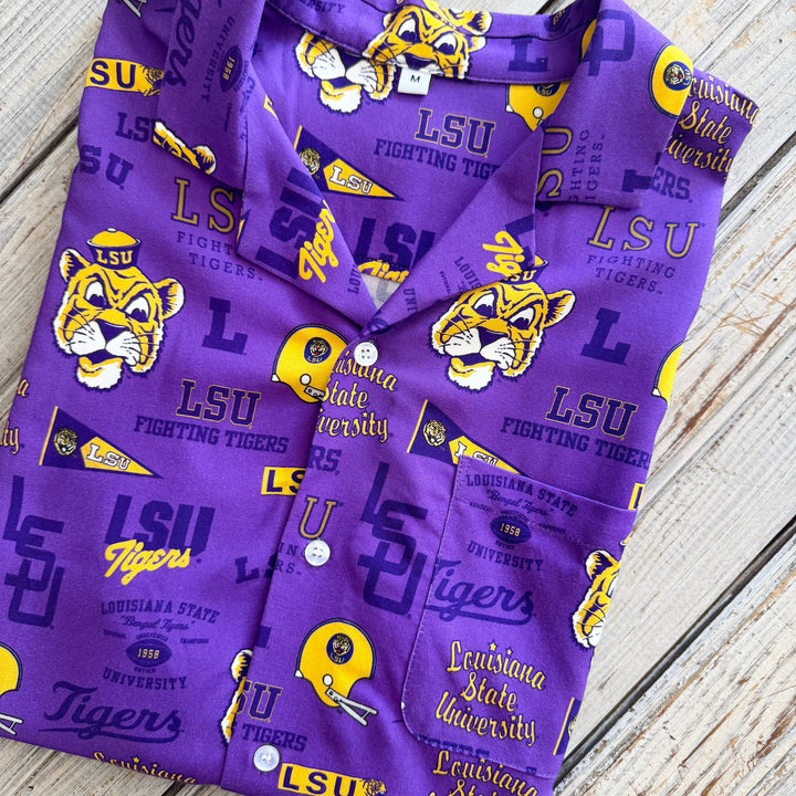 Folded purple button-up shirt with an LSU Fighting Tigers print in gold and white