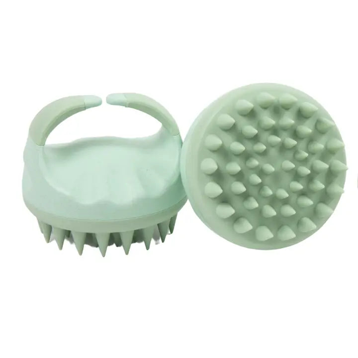 Product photography of two mint green silicone scalp massagers on a white background featuring ergonomic hand-grip handles and flexible cone-shaped bristles arranged in concentric circles