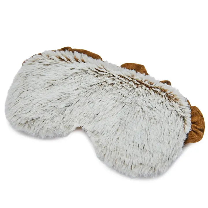 Faux fur and textile animal-themed sleep mask featuring speckled white and brown plush textures and small brown fabric ears on a plain white background