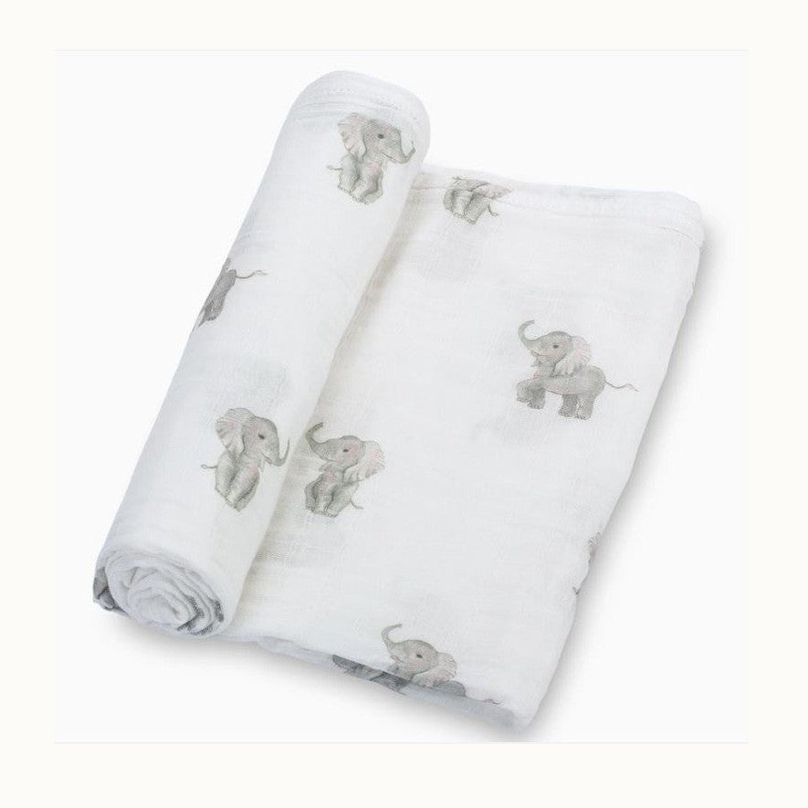 Muslin cotton baby swaddle blanket featuring a watercolor illustration of soft grey elephants with pink inner ears and thin curved tails scattered across a textured white fabric background