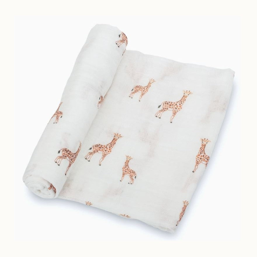 Product photograph of a white cotton muslin swaddle blanket featuring watercolor-style brown spotted giraffes and the Eiffel Tower in a soft-toned repeat pattern against a clean studio backdrop