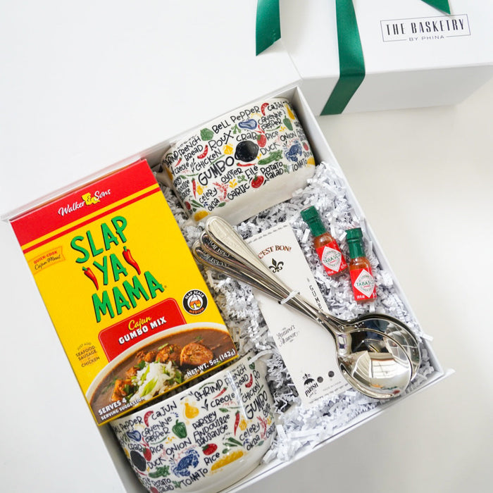 Slap Ya Mama cornbread mix with a mug, spoon, and decorative box on a white background