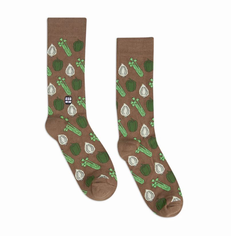Woven crew socks by Dapper Classics featuring the Cajun Holy Trinity of green bell peppers, white onions, and green celery stalks on a brown background with a small New Orleans streetcar logo
