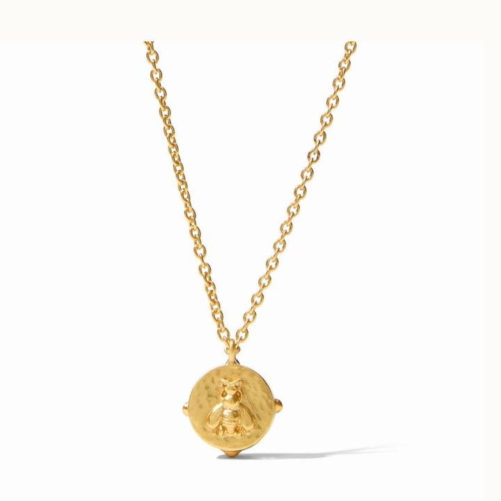 Gold-plated jewelry by Julie Vos featuring a honeybee coin pendant with a hammered texture and raised relief detail suspended from a dainty cable chain against a white background