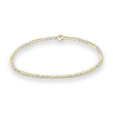 Beaded jewelry bracelet on a white background featuring polished gold spheres, matte grey disc-shaped spacers, and a single large gold-tone bead at the center focal point