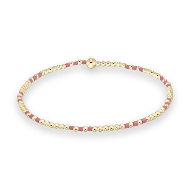 Gold bead jewelry design by enewton featuring a Classic Hope Unwritten stretch bracelet on a white background showcasing 14kt gold-filled round beads, matte pink block spacers, and a signature oversized high-polish gold sphere