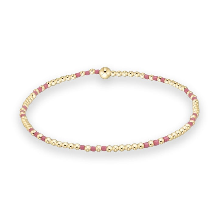Gold bead jewelry design by enewton featuring a Classic Hope Unwritten stretch bracelet on a white background showcasing 14kt gold-filled round beads, matte pink block spacers, and a signature oversized high-polish gold sphere