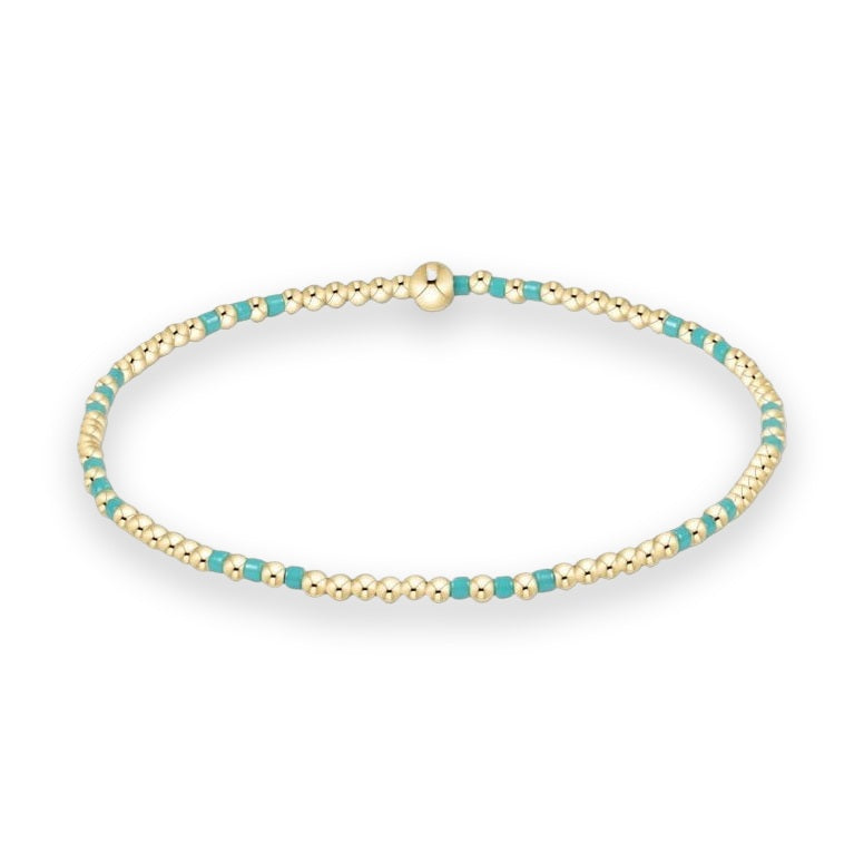 Beaded bracelet by enewton showcasing a delicate arrangement of polished 14kt gold-filled spheres and vibrant turquoise enamel spacers with a central signature gold bead on a crisp white background