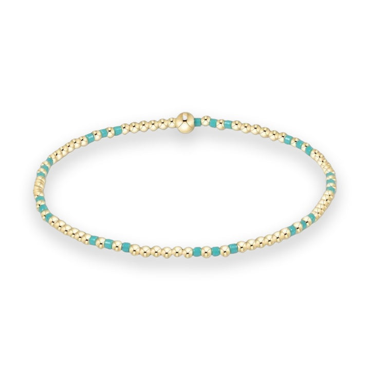 Beaded bracelet by enewton showcasing a delicate arrangement of polished 14kt gold-filled spheres and vibrant turquoise enamel spacers with a central signature gold bead on a crisp white background