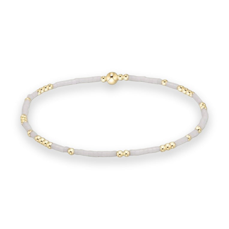 Beaded bracelet by enewton on a white background featuring matte white seed beads, clusters of 14kt gold-filled beads, and a signature central large gold bead