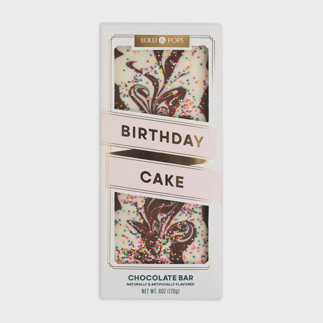 Lolli and Pops Birthday Cake chocolate bar featuring white chocolate with dark chocolate swirls and multi-colored rainbow sprinkles accented by gold foil lettering on a minimalist light gray background