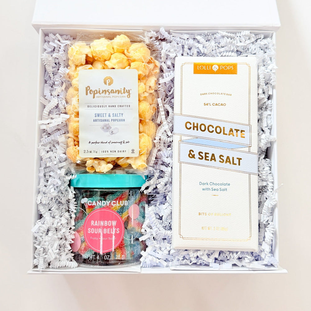 Gift box with popcorn, chocolate, and sea salt packaging on a white background