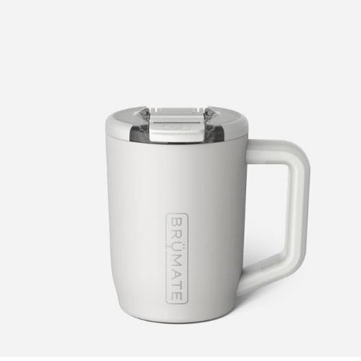 Product photography by BrüMate of a matte white insulated travel mug in a studio setting featuring a vertical embossed logo, a clear splash-proof lid with a sliding latch, and an ergonomic handle