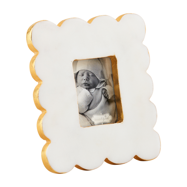 White marble scalloped rectangular frame with gold edges holding a photo of a baby