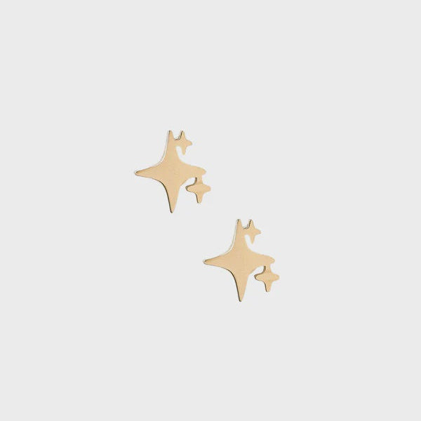 Gold stud earrings featuring a celestial sparkle design with a cluster of three polished yellow gold four-pointed stars against a minimalist light gray background
