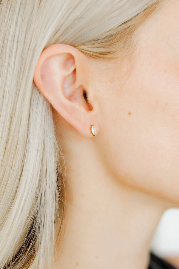 Photograph of a gold marquise-cut diamond stud earring on a woman&