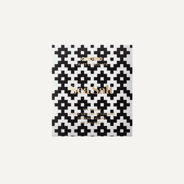 Graphic design packaging by Goodio features a Sea Salt chocolate bar from Finland highlighting a bold black and white pixelated geometric pattern, elegant gold foil typography, and a minimalist white background