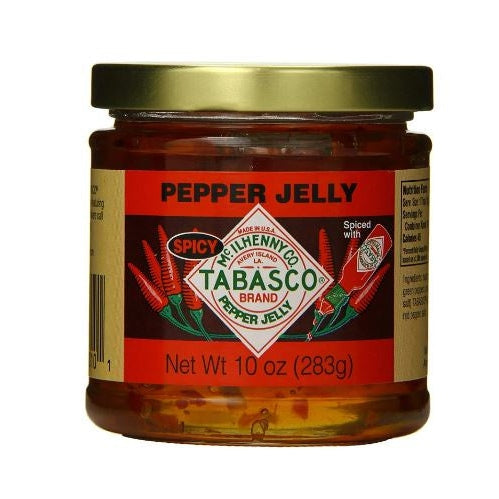 Photograph by McIlhenny Company of a 10 oz jar of Tabasco Brand Spicy Pepper Jelly against a white backdrop featuring the iconic diamond logo referencing Avery Island, a gold metal lid, and red chili pepper illustrations on the label showing translucent amber-colored jelly