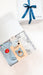 Baby gift set with clothes, blanket, and teether on a white surface