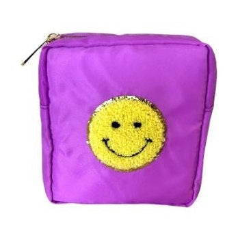 Nylon fabric accessory pouch featuring a textured yellow chenille smiley face patch with a sparkling gold sequin border and a gold-tone zipper pull on a white studio background