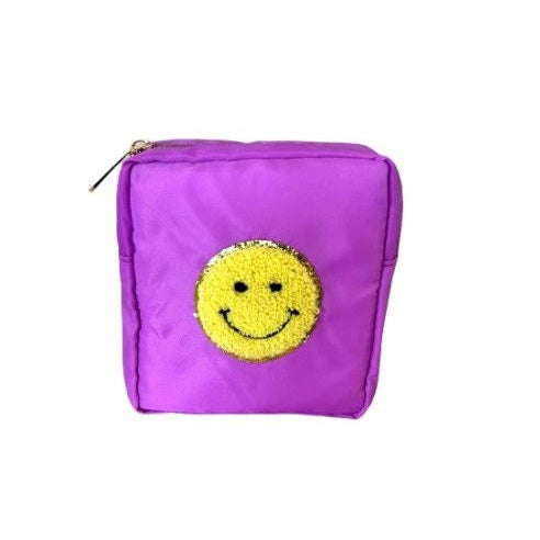 Nylon fabric accessory pouch featuring a textured yellow chenille smiley face patch with a sparkling gold sequin border and a gold-tone zipper pull on a white studio background