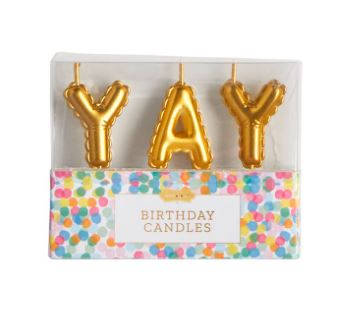 Gold metallic birthday candles shaped like inflated balloons spelling the word YAY and packaged in a clear box with a vibrant multicolored confetti-patterned base labeled BIRTHDAY CANDLES