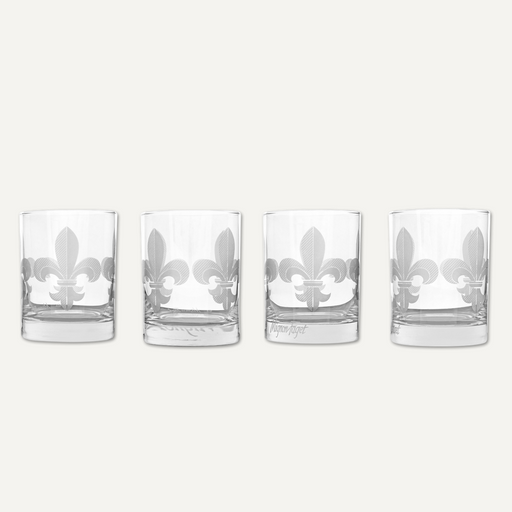 Etched glassware by Mignon Faget featuring a set of four rocks glasses against a neutral background showcasing the iconic New Orleans fleur-de-lis with a frosted cross-hatched pattern and heavy weighted bases